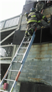 Firefighter at the Top of a Ladder Carrying Another Firefighter