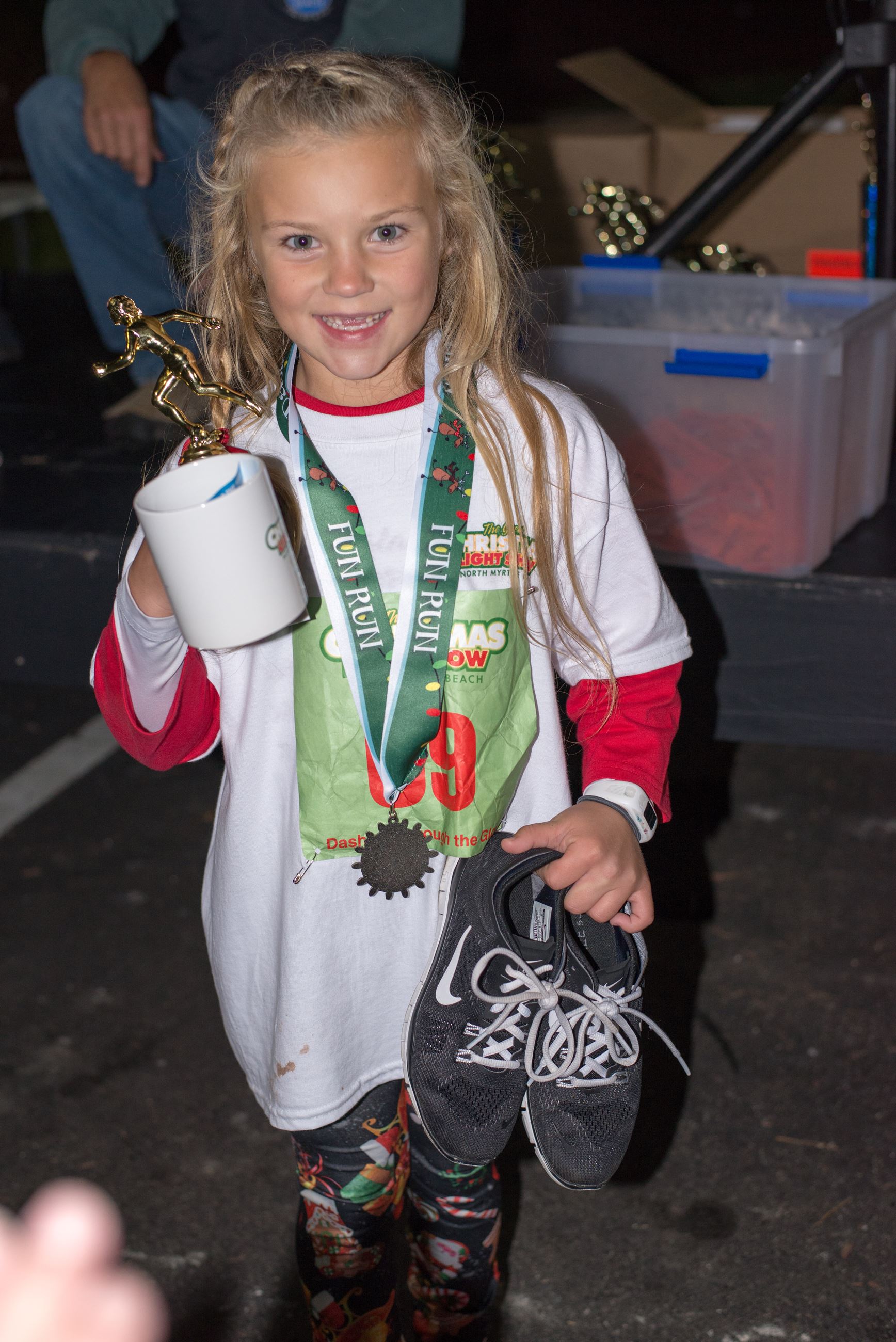 Young Girl Holding a Mug, Trophy, and Shoes